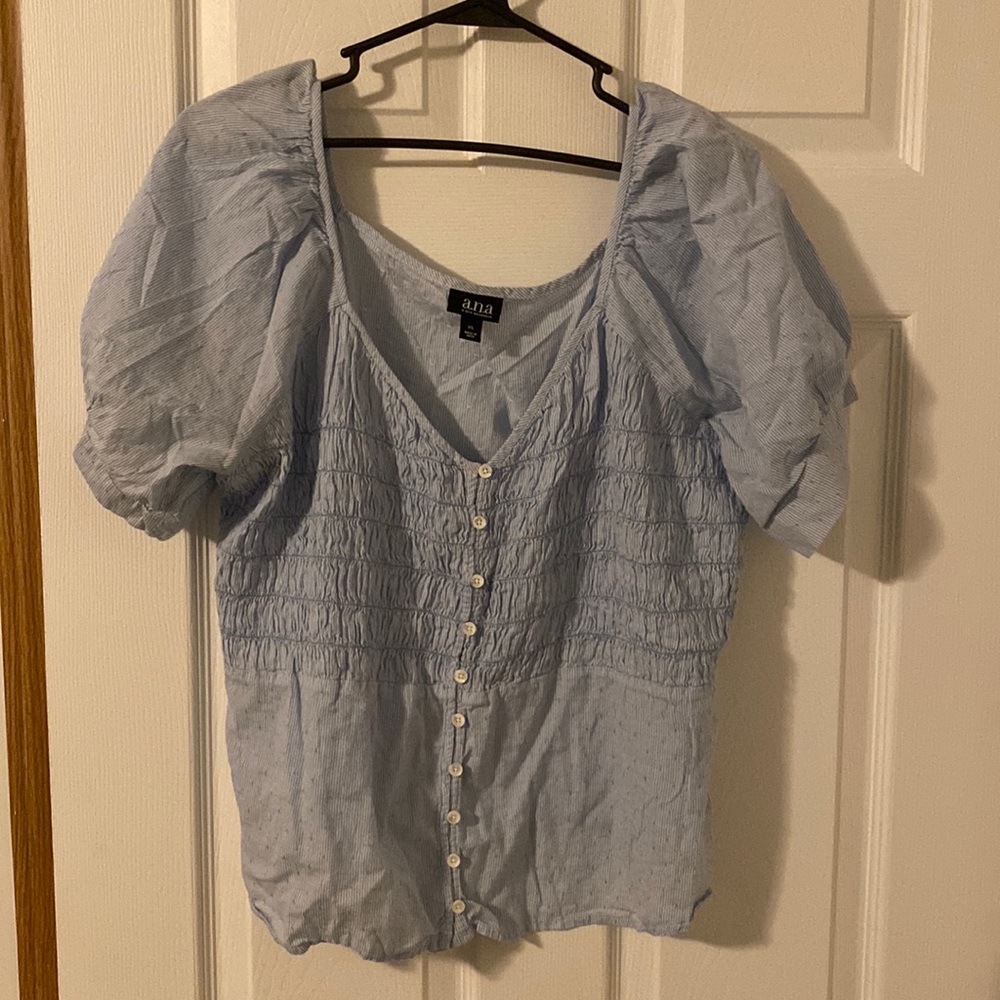 Baby blue shirt with puffy sleeves.
